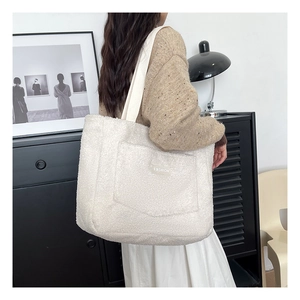 Close-up of white fleece tote bag with 'FASHION' patch and thick woven shoulder strap