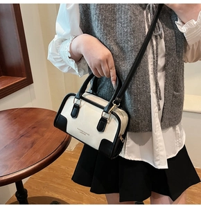 Fashionable black and white contrast handbag with elegant top handles and shoulder strap
