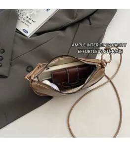 Vue détaillée de l'intérieur spacieux d'un sac bandoulière en cuir marron avec accessoires
