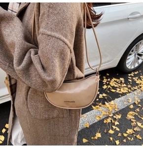 Gros plan d'un sac demi-lune kaki avec fermeture éclair et imprimé mode élégant