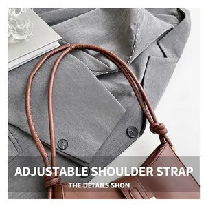 Gros plan d'un sac en cuir marron avec bandoulière nouée réglable sur une veste