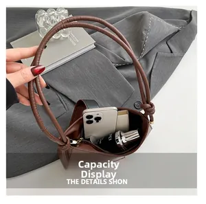Gros plan de l'intérieur du sac en cuir marron montrant sa capacité de rangement