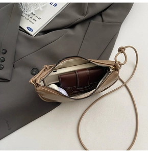 Vue de dessus d'un sac demi-lune kaki montrant l'intérieur spacieux pour accessoires