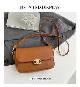 Vue détaillée d'un sac à bandoulière marron avec boucle ovale dorée en métal chic