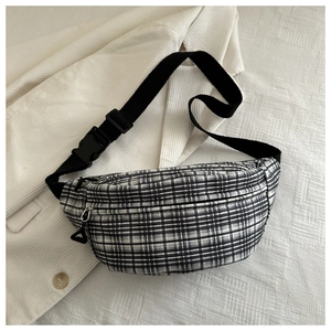 Detail of checkered canvas waist bag with adjustable strap on white corduroy jacket
