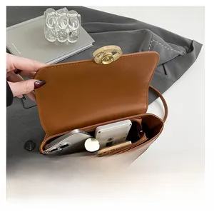 Vue de dessus d'un sac bandoulière en cuir marron montrant l'espace intérieur et le fermoir