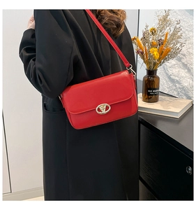 Détail du sac à bandoulière en cuir rouge avec boucle en V dorée et rabat rectangulaire