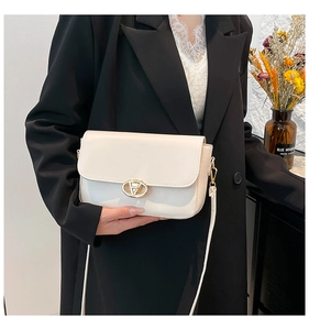 Détail du sac baguette blanc cassé avec boucle logo dorée et fine bandoulière en cuir