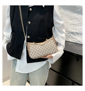 Detail of vintage pattern shoulder bag with gold chain strap and floral zipper puller