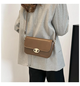 Détail d'un sac vintage en cuir marron avec fermoir doré et bandoulière réglable