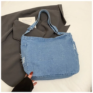 Detail of adjustable strap buckle and distressed denim fabric on tote bag