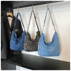 Detailed display of vintage denim tote bags in blue and grey with adjustable straps