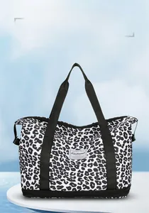 Detail of leopard print travel fitness bag featuring bottom expansion layer and logo