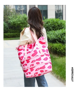 Pink leopard print travel bag with expandable zipper base held by model in garden