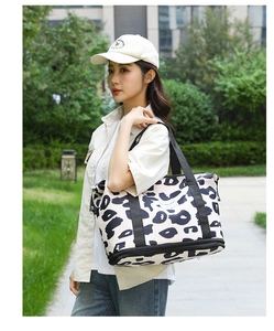 Detail of leopard print travel tote showing the reinforced base and bottom zipper compartment