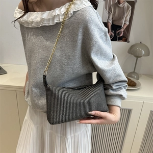 Sac baguette tissé noir et blanc minimaliste avec une élégante bandoulière dorée