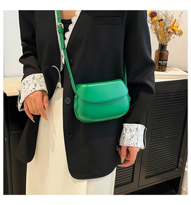 Detailed view of a bright green saddle bag with smooth leather finish and metal buckle