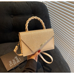 Détail du sac à main beige avec paillettes dorées scintillantes et poignée tressée
