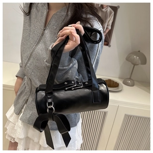 Detail of black Boston bag with silver buckles and a large decorative bow accessory