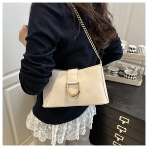 Detail of cream white underarm bag featuring glossy finish and a gold D-buckle closure