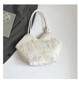 Detail of white leather tote with colorful wave embroidery and embossed m pattern