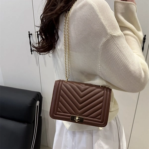 Brown quilted crossbody bag with V-shaped stitching and golden chain strap for women