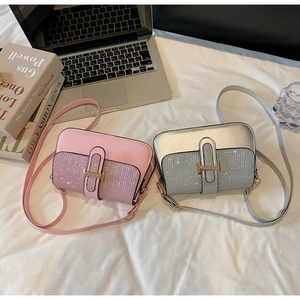 Detail view of pink and silver glitter crossbody bags with elegant H-shaped metal buckles