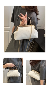 Detail of retro cream white clutch with textured fabric and vintage gold chain strap