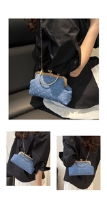 Detail of blue denim crossbody bag with white heart embroidery and metallic gold handle