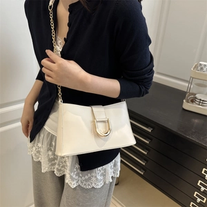 Chic cream white underarm bag with glossy finish and gold D-shaped buckle on chain strap
