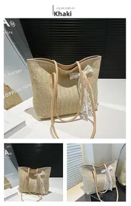 Detail of khaki straw tote bag with herringbone weave, lace bow and brown leather strap
