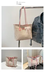Detail of straw woven tote bag featuring a pink leather strap and white lace bow