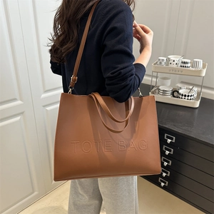 Brown leather large tote bag with embossed lettering and adjustable shoulder strap