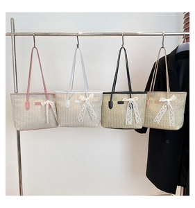 Detail of woven straw tote bags with lace bow accents and leather handles in four colors