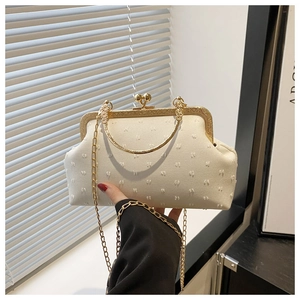 Detail of vintage cream textured dinner bag with pearl clasp and gold metal handle