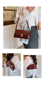 Close-up of burgundy retro rectangular underarm bag with gold metal buckle detail