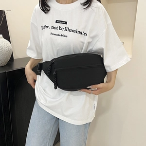 Chic black half-moon crossbody chest bag with wide strap and woven zipper details