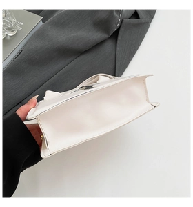 Details des flachen Bodens der weißen Modetasche mit präzisen Nähten und Ledertextur