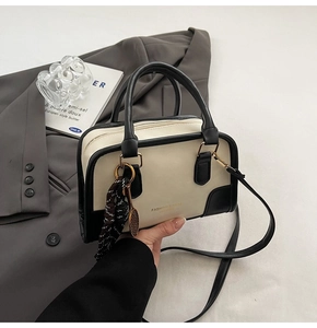 Dettaglio borsa vintage beige con finiture nere ed elegante foulard in seta sottile