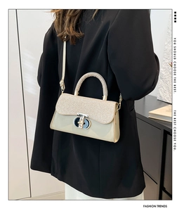Détail du fermoir tournant en métal et des textures mixtes sur un sac à chaîne beige