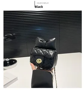 Close-up of black quilted mini bag with fluffy bow detail and golden twist lock clasp