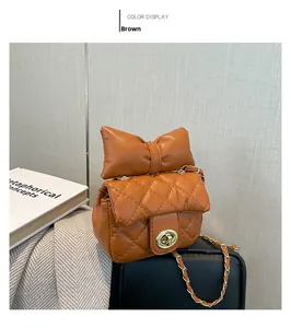Detail of a brown quilted crossbody bag with a large bow and gold metal chain strap