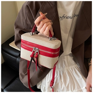 Red leather trim canvas box bag shown on model with adjustable shoulder strap