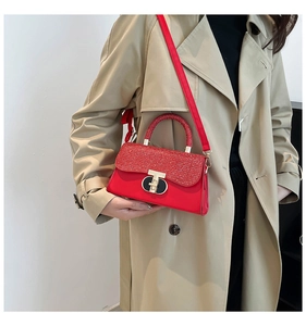 Sac à bandoulière carré rouge porté avec un trench-coat beige pour un look élégant