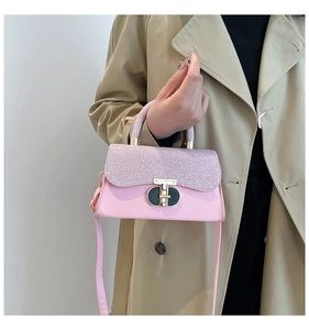 Sac à main rose brillant avec texture pailletée et fermoir rotatif doré en gros plan