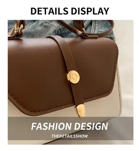 Close-up of the beige and brown leather handbag featuring a golden circular clasp