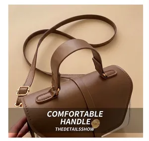 Close-up of brown and white two-tone leather bag with golden metal buckle hardware