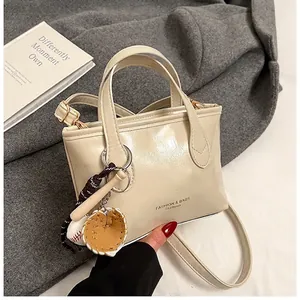 Detailed view of beige PU leather tote with baseball charm and fashion text