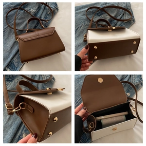 Detail view of contrast color crossbody bag with metal handle and interior capacity