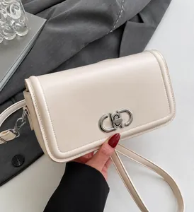Detail of minimalist cream leather bag showing silver metal buckle and premium texture